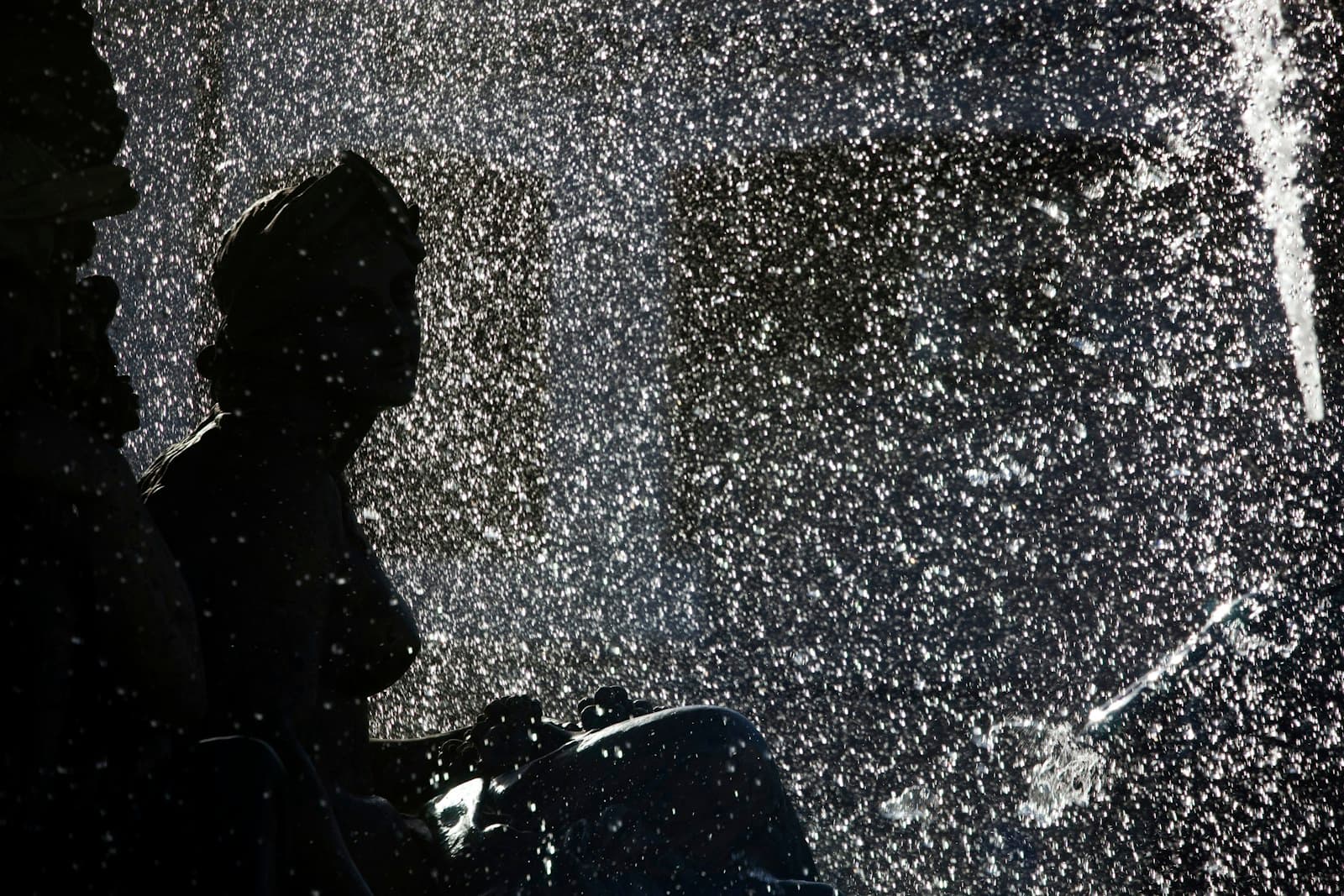 A traveler waiting in wet weather with a suitcase
